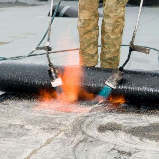 Plat dak branden door dakdekker in Dieren